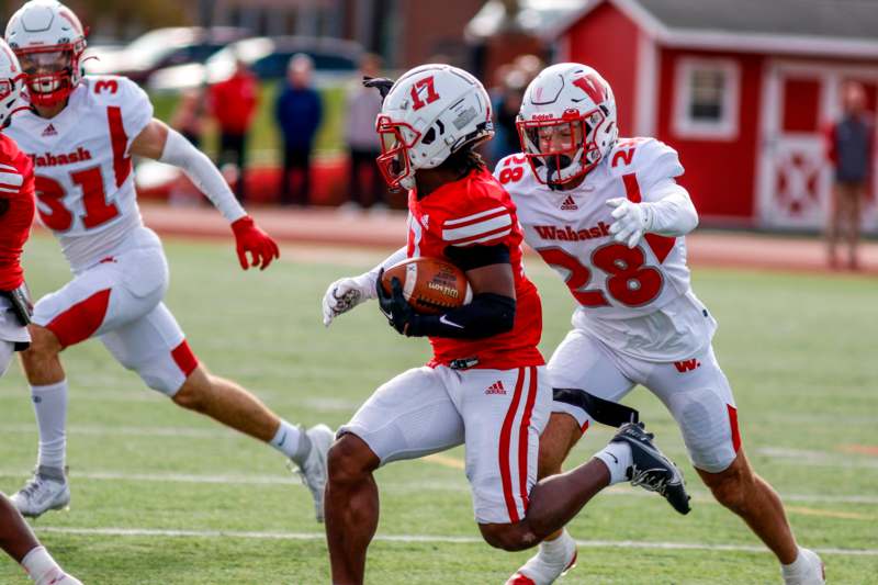 a group of football players running on a field