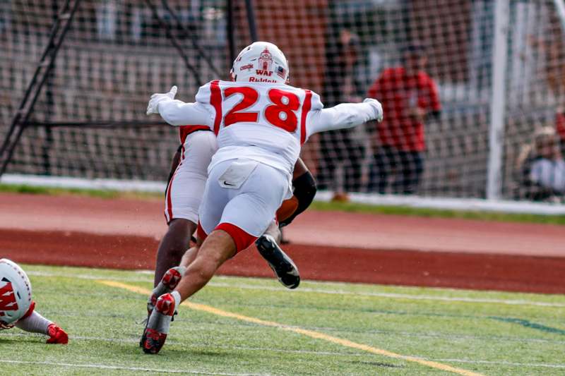 a football player running with another player in the air