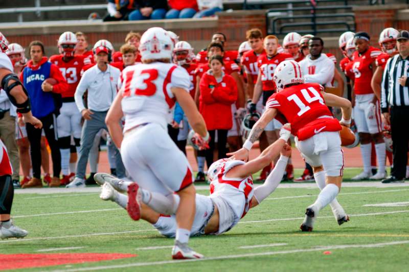 a football player falling into another player on a field