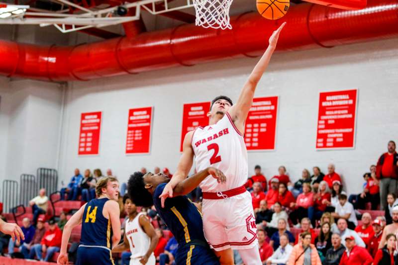 a basketball player in a red uniform jumping to block a basketball