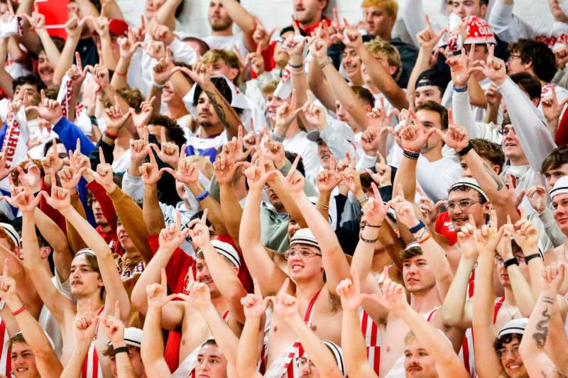 a large group of people holding up their hands