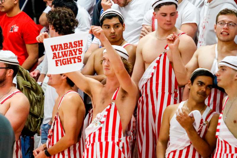 a group of men wearing striped overalls and holding a sign