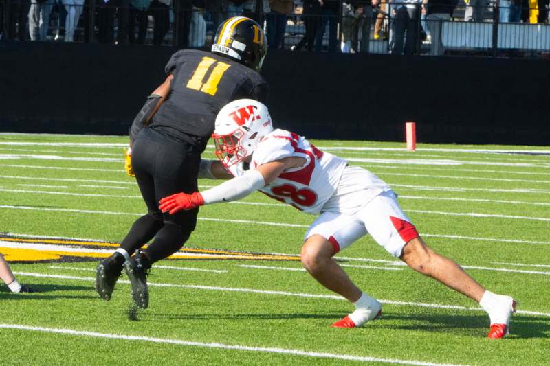 a football player in a helmet chasing another football player