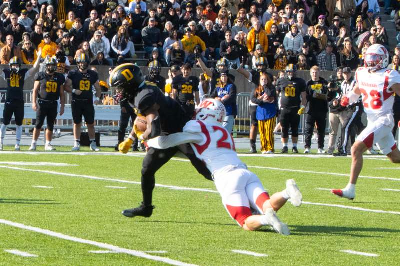 a football player falling down to catch a football