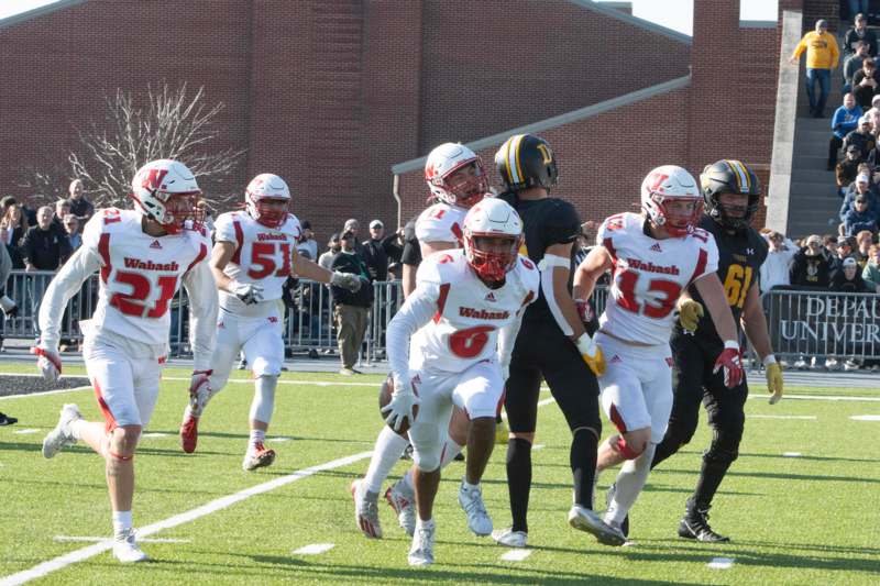 a group of football players running on a field