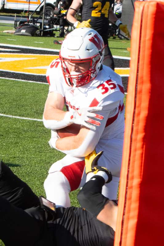 a football player in a uniform holding a football