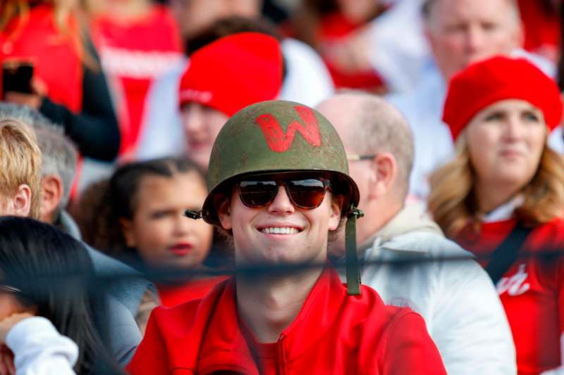 a man in a red jacket and sunglasses smiling