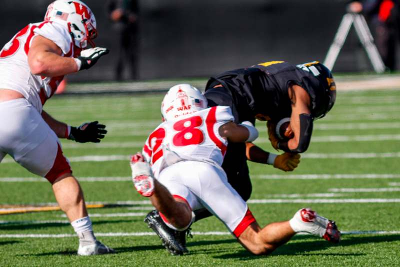 a football player falling down while another player is falling down