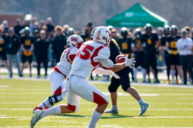 a football player in a white uniform with a red ball in his hand