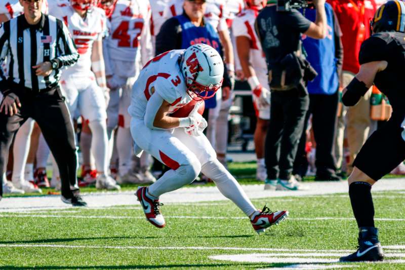 a football player in a white uniform running on a field