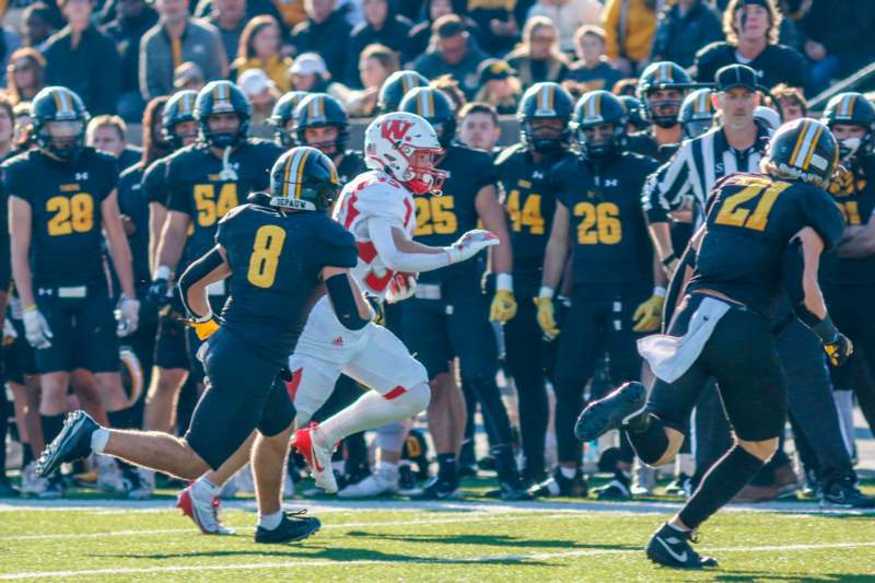 a football player running with a crowd of people in the background