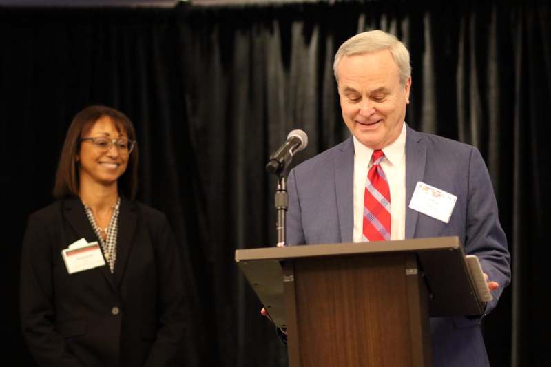 a man standing at a podium with a microphone