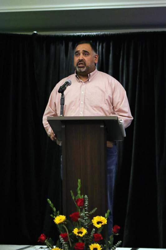 a man standing at a podium with a microphone