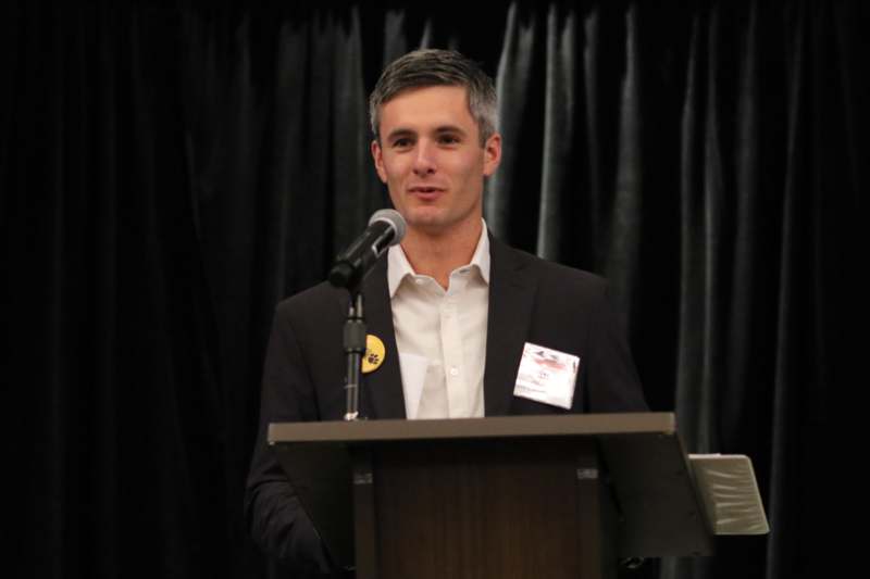 a man standing at a podium with a microphone