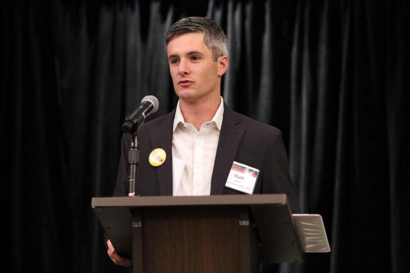 a man standing at a podium with a microphone