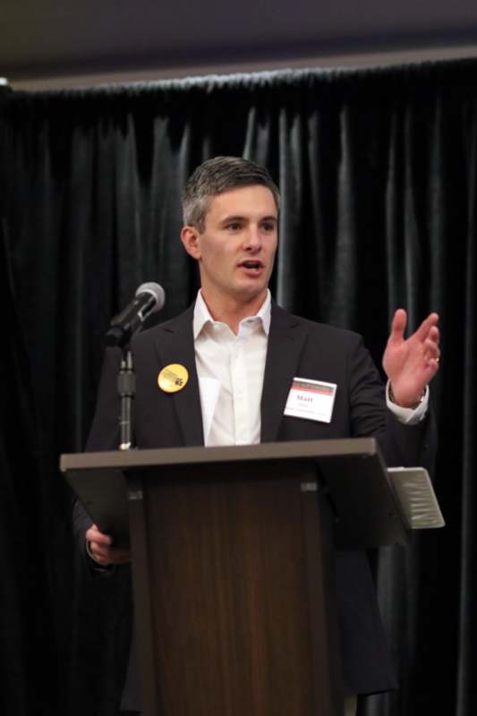 a man standing at a podium with a microphone