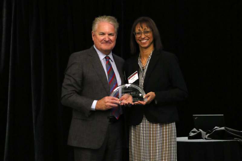 a man and woman holding a glass award