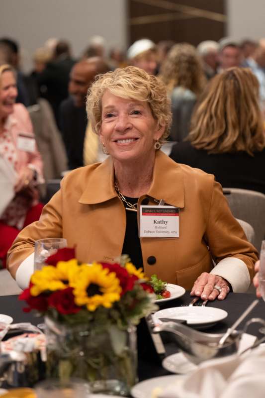 a woman sitting at a table with flowers