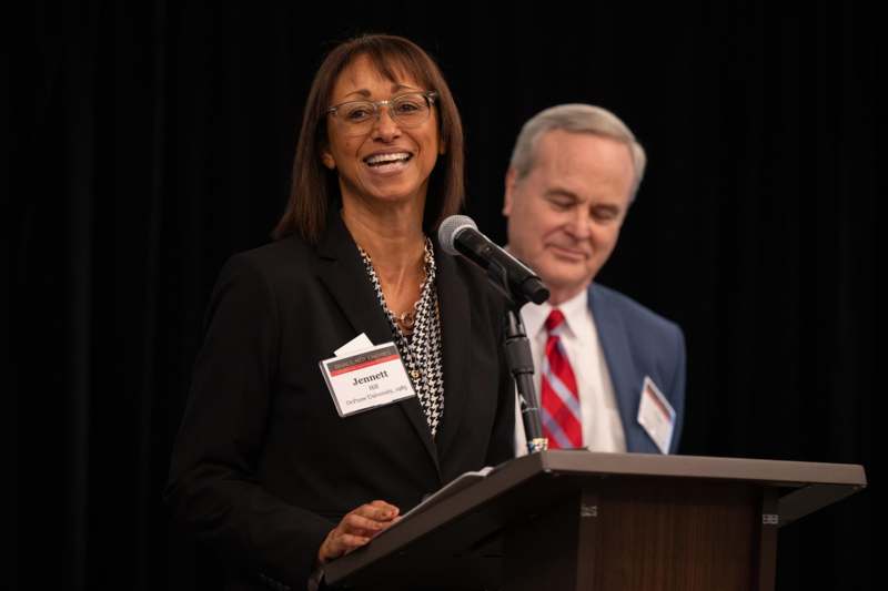 a woman standing at a podium with a microphone