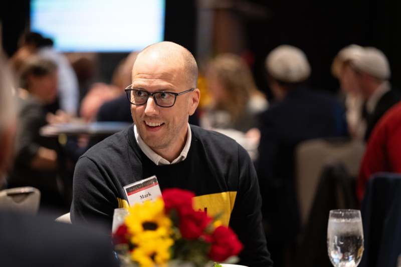 a man sitting at a table with flowers