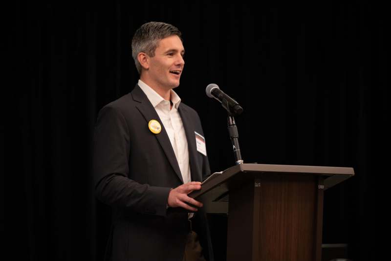 a man standing at a podium with a microphone