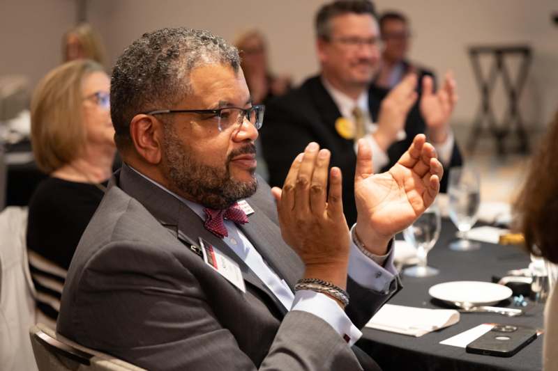 a man in a suit clapping his hands