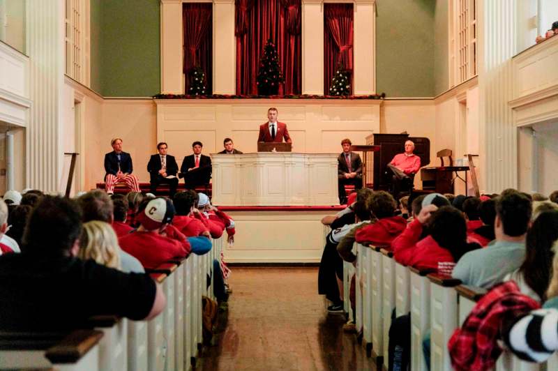 a group of people sitting in chairs in a church