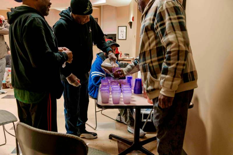 a group of people standing around a table with cups