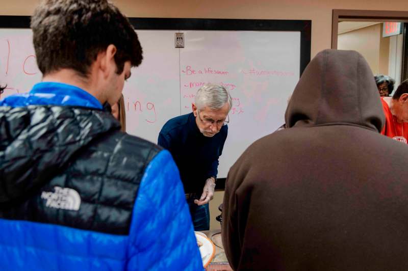 a group of people standing around a whiteboard