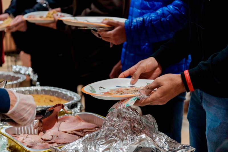 a group of people holding plates of food