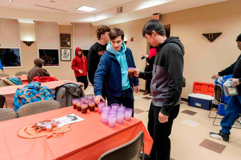 a group of people standing around a table with cups