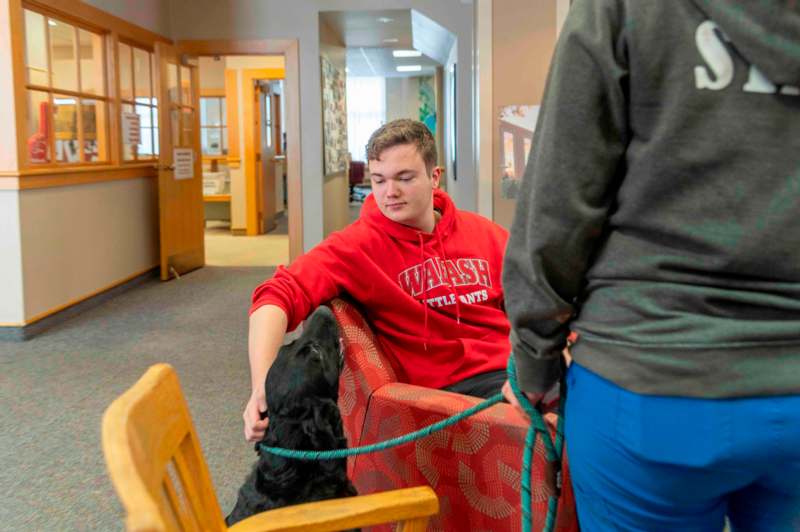 a man in a red sweatshirt with a dog on a leash