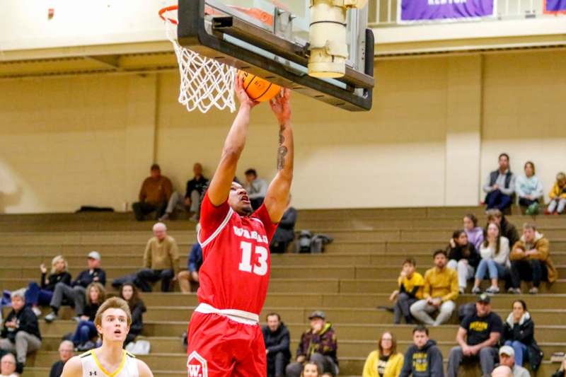 a basketball player dunking a basketball in a gym