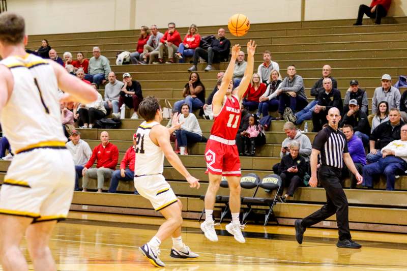 a basketball player jumping to shoot a ball