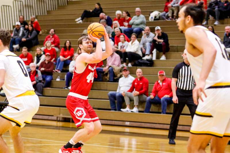 a basketball player in red uniform with a ball in his hand