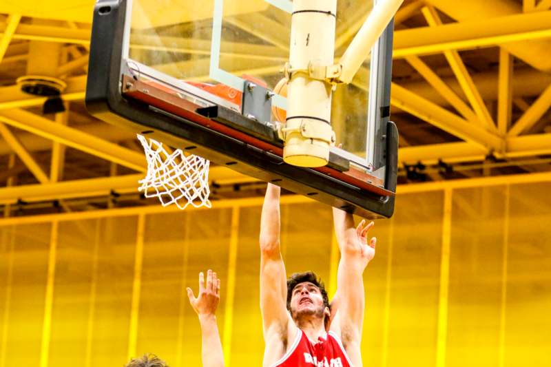 a man in a basketball jersey dunking a basketball hoop