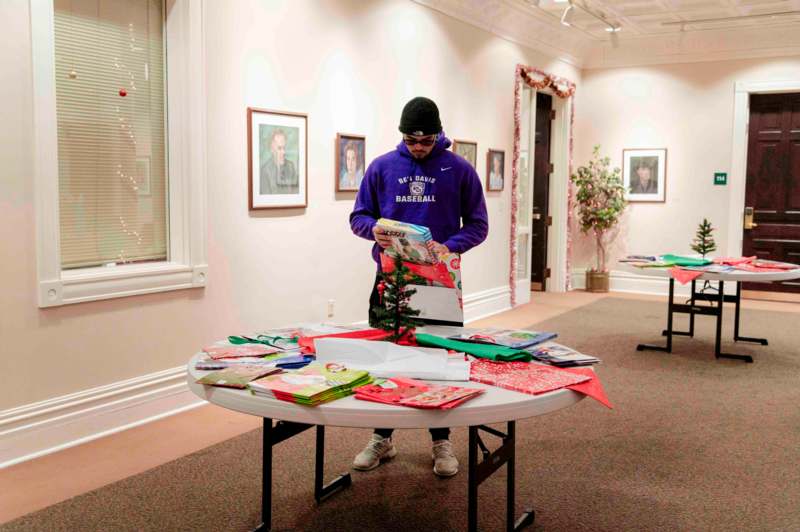 a man standing in a room with a table full of presents