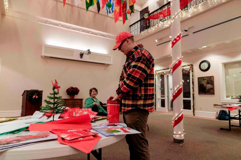 a man in a red hat and plaid shirt opening a bag