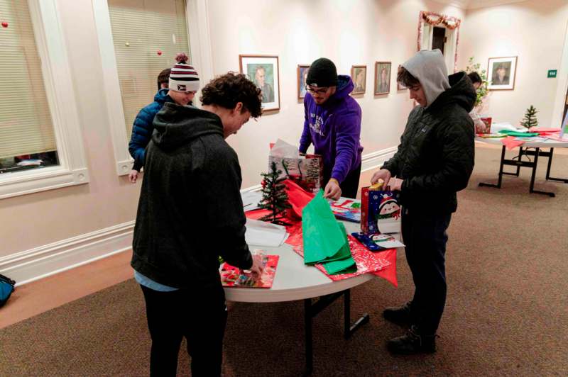 a group of people around a table with presents