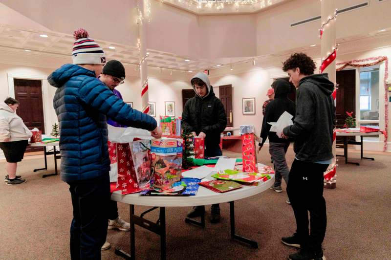 a group of people around a table with presents