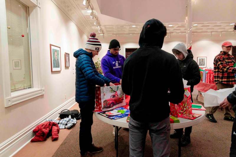 a group of people standing around a table with presents