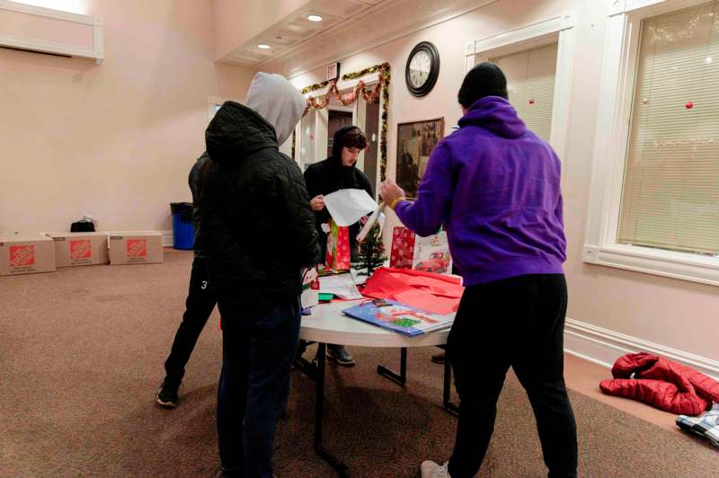 a group of people around a table with presents