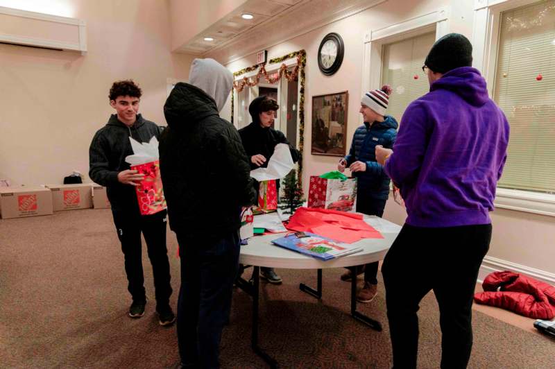 a group of people standing around a table with presents