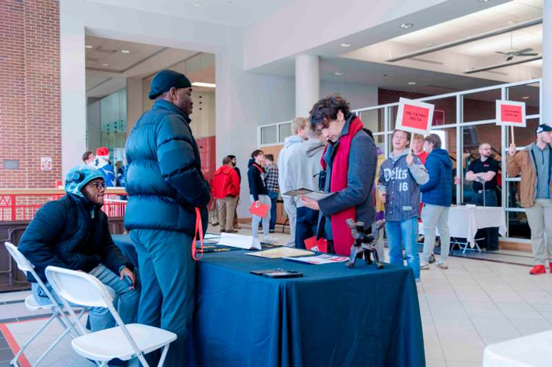 a group of people standing around a table