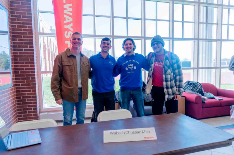 a group of men standing in front of a table