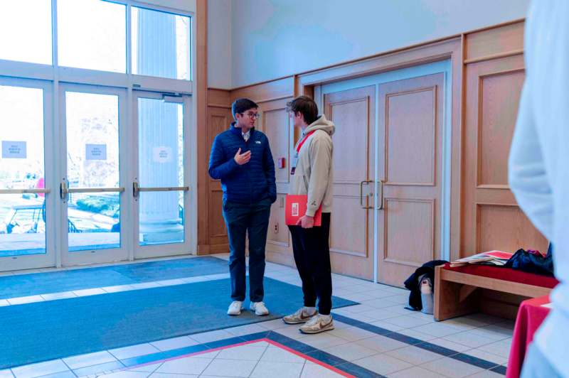 two men standing in a hallway