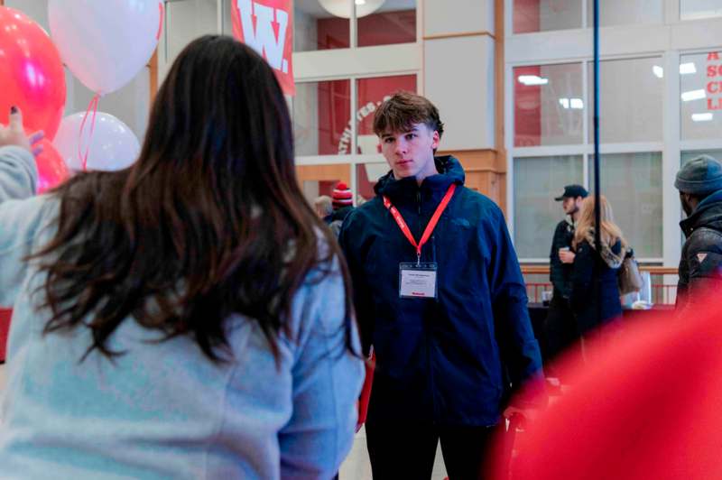 a man standing in a room with people in the background