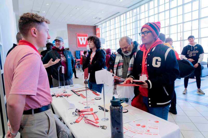 a group of people standing around a table with signs