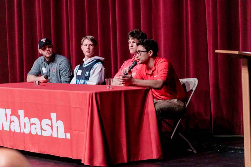 a group of men sitting at a table with microphones