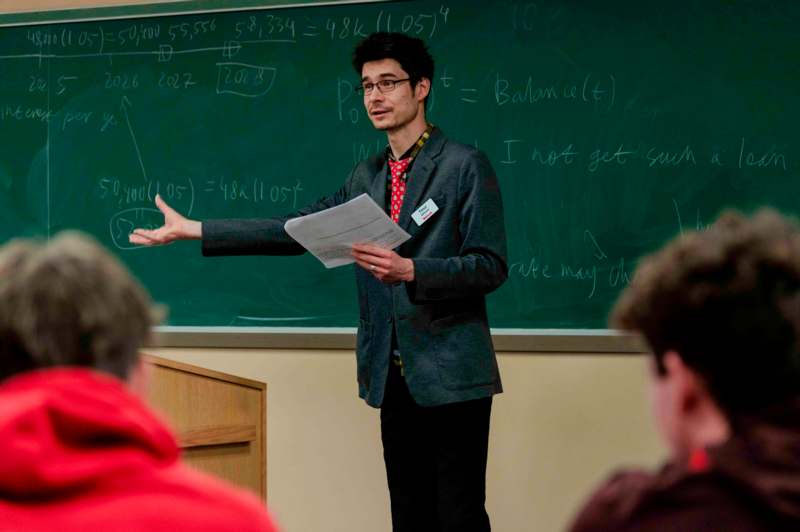 a man standing in front of a chalkboard